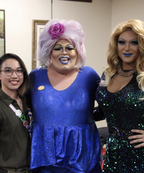 Drag queens Annie Manildoo and Bella Noche posing for picture with student