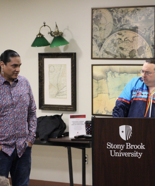 Filmmaker Ginew Benton being introduced in front of the room